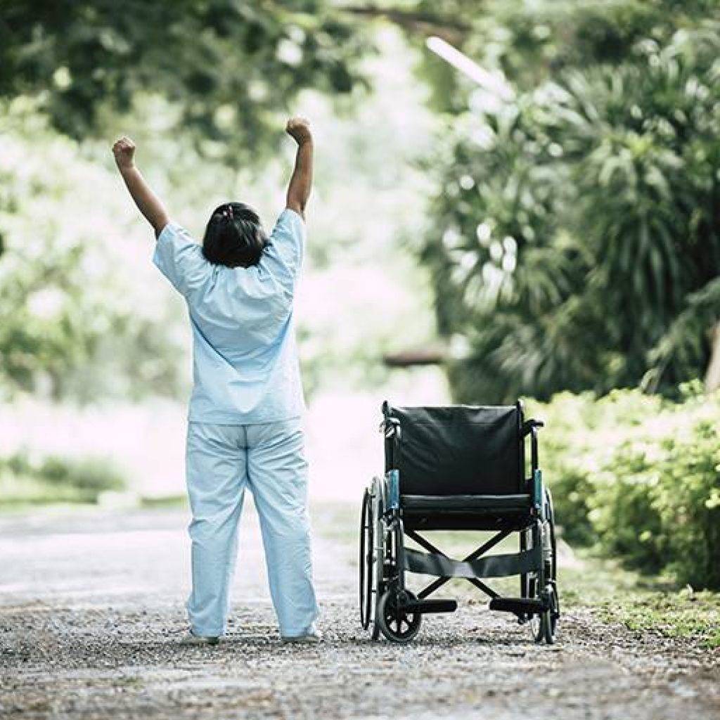Physical therapy senior woman with wheelchair in the park